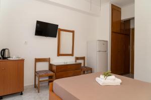 a room with a table and a kitchen with a refrigerator at Posidonia Pension in Amarynthos