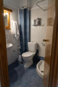 a bathroom with a toilet and a sink at Posidonia Pension in Amarynthos +27 photos