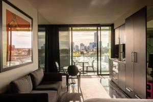 a living room with a couch and a view of a city at Elli Prahran in Melbourne