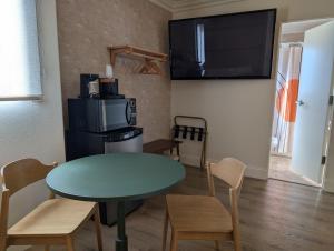 a small dining room with a table and a microwave at Sunset Motel in Santa Barbara