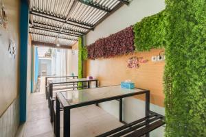 a room with tables and a green wall at RedDoorz Plus near Palembang Icon Mall 2 in Palembang