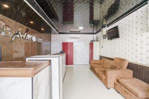 a room with a bar and a couch and a tv at RedDoorz Plus near Palembang Icon Mall 2 in Palembang