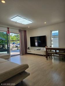 a living room with a large flat screen tv at Twin Stay1 in Yonghwa