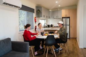 a group of people sitting around a table in a kitchen at BIG4 Rutherglen Holiday Park in Rutherglen