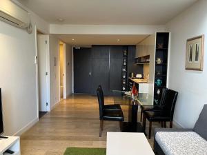 a living room with a glass table and chairs at Camberwell Vacation Apartment in Melbourne