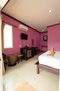 a bedroom with pink walls and a bed and a tv at ไข่ปูพูลเกาะล้าน in Ko Larn +14 photos