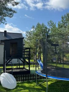 a playground with a slide and a swing set at Lobeliowe Domki in Chośnica