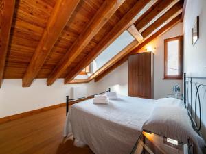 a bedroom with a large bed in a room with wooden ceilings at Attic historic building with air conditioning in Ceresole Reale