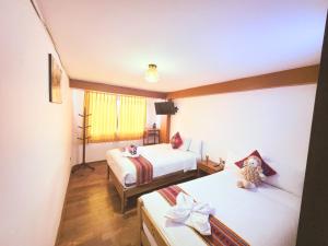 a hotel room with two beds and a television at Hotel Mirador All Sur in Cusco