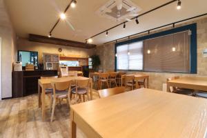 a dining room with wooden tables and chairs at ボウケンノモリささぐり in Sasaguri