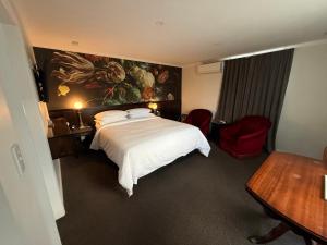 a hotel room with a bed and a painting on the wall at Art Deco BNB in Havelock North