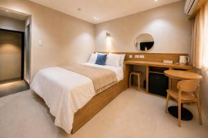 a hotel room with a bed and a desk at 부산 수영 블루닷 호텔 in Busan