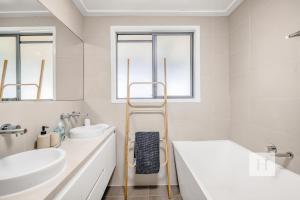 a white bathroom with a sink and a towel rack at Sunrise Waters in Gorokan +20 photos