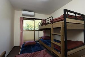 two bunk beds in a room with a window at ボウケンノモリささぐり in Sasaguri