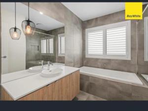 a bathroom with a tub and a sink and a bath tub at Serenity in Melton South +12 photos