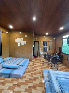 a room with three beds and a table in it at Táo House in Vĩnh Hy