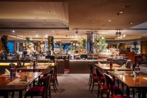 a restaurant with tables and chairs and a bar at The Emerald Hotel Bangkok Ratchada in Bangkok
