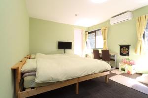 a bedroom with a bed and a desk and a chair at ボウケンノモリささぐり in Sasaguri