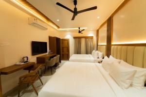 a hotel room with two beds and a desk at PSR Coral Resorts, 800m Away from Rameswaram Temple in Rāmeswaram +55 photos