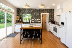 a kitchen with white cabinets and a table with stools at LeWeber Haus in Leavenworth