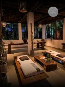 a room with two beds and tables and windows at Tropical Garden House in Siem Reap