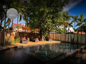 a swimming pool in a yard with trees and a fence at Tropical Garden House in Siem Reap