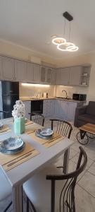 a kitchen with a white table with chairs and a tableablish at LASKARINA'S HOUSE in Skala Potamias