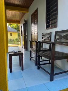 a room with two wooden chairs and a table at La maison jaune in Nosy Be