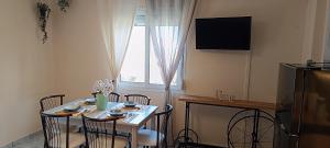 a small dining room table with chairs and a window at LASKARINA'S HOUSE in Skala Potamias