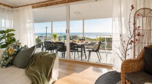 a living room with a dining table and a view of the ocean at Absolute Beachfront Escape Family Retreat in Mandurah