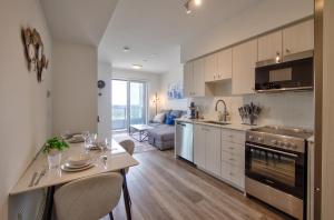 a kitchen and living room with a table and a couch at Cozy Condo in Downtown KW in Kitchener
