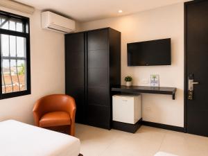 a bedroom with a bed and a tv on a wall at Hotel Habitat San Antonio in Cali