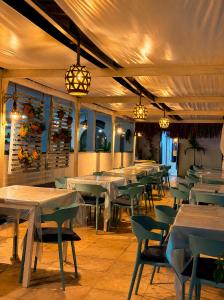 a dining room with tables and chairs and lights at La Suite Praia Hotel in Caucaia