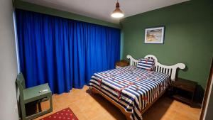 a bedroom with a bed and a blue curtain at Costa lisa in Cabarete