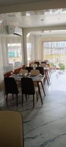a dining room with tables and chairs in a building at The Highway Haven in Silchar
