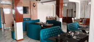 a restaurant with blue chairs and tables in a room at The Highway Haven in Silchar