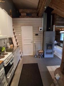 a kitchen with a white door and a stove at Iso-Syöte tunnelmallinen kelomökki in Naamanka