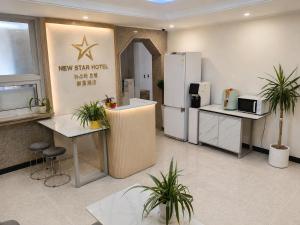 a kitchen with a refrigerator and tables and potted plants at New Star Hotel in Chu-sung