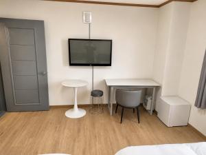 a room with a table and a tv on the wall at New Star Hotel in Chu-sung