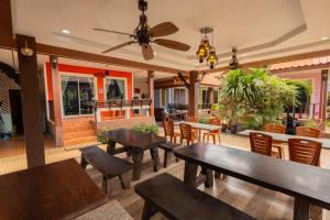 a restaurant with tables and chairs and a ceiling fan at ไข่มุกรีสอร์ทเกาะล้าน in Ko Larn