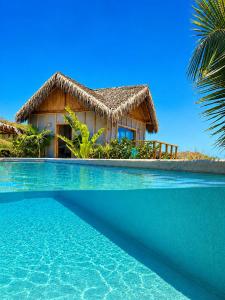 a resort with a swimming pool in front of a house at La Cabaña de Iza in Canoas