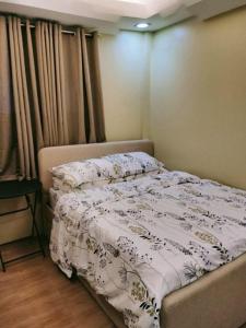 a bedroom with a bed with a white comforter at W Island Backpackers Inn in Dauis
