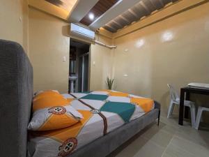 a bedroom with a bed in a room with a table at W Island Backpackers Inn in Dauis