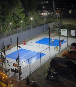 a tennis court at night with people on it at W Island Backpackers Inn in Dauis