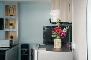 a vase of roses sitting on top of a refrigerator at Kathmandu Mountain view Studio in Bālāju