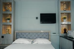 a bedroom with a bed with a tv on the wall at Kathmandu Mountain view Studio in Bālāju