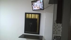 a mirror on a wall with a tv on the wall at Apartaestudios El Cable in Manizales