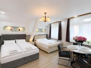 a bedroom with two beds and a table and chairs at Hostel am Rhein - Nierstein in Nierstein