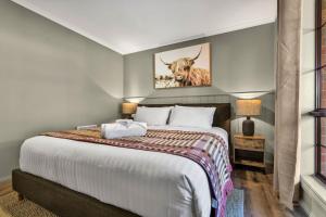 a bedroom with a large bed with a picture of a bull at Plum Pines Bright in Bright +15 photos