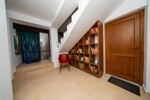 a hallway with a book shelf and a red chair at Pescariei Nr5 in Sarichioi